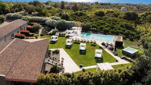 Ein Resort mit Swimmingpool, Liegestühlen und Meerblick.