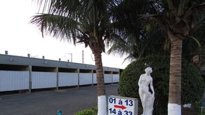 Un estacionamiento con puertas de garaje numeradas y una estatua de una mujer.