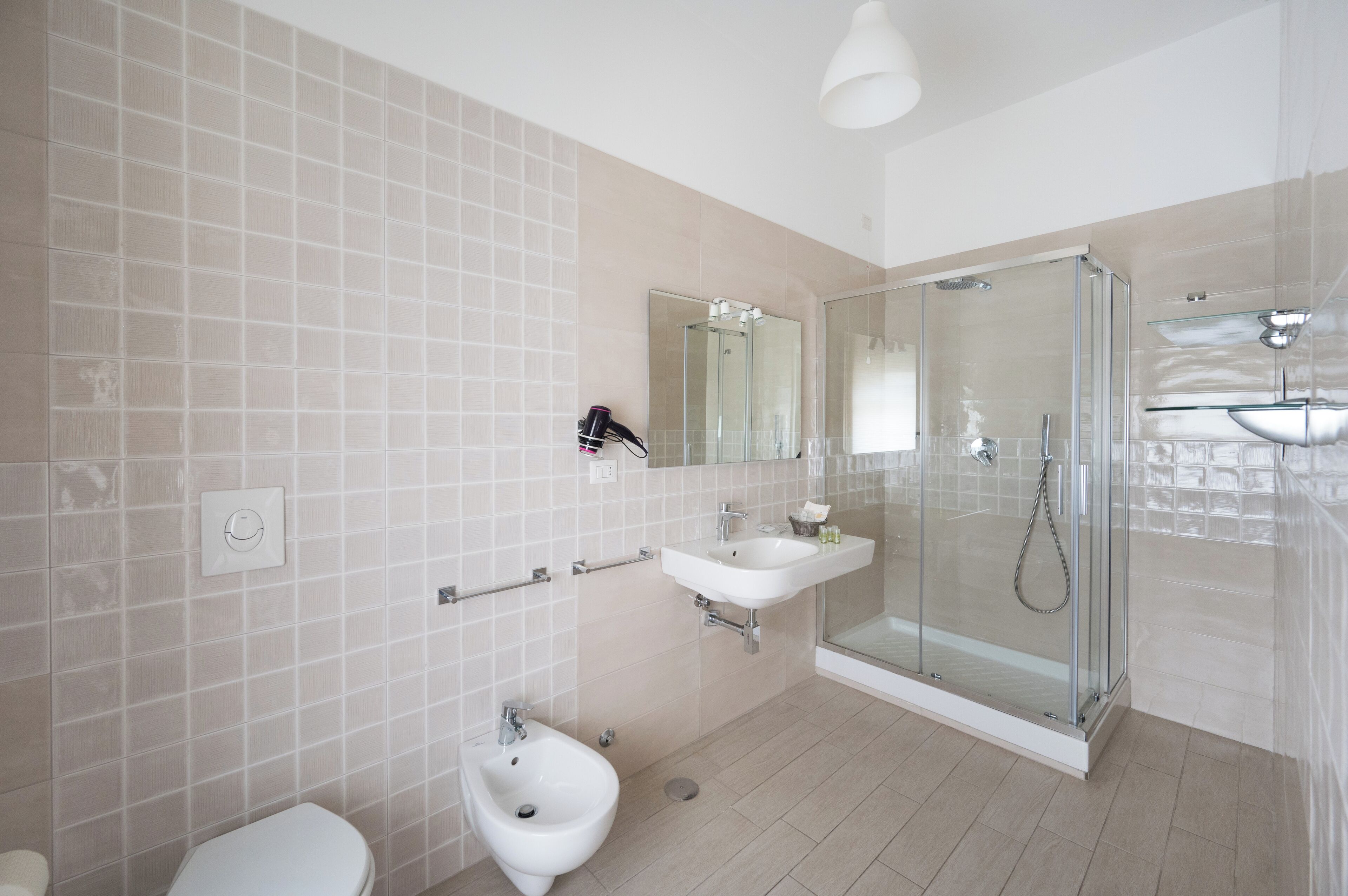 Une salle de bain moderne avec une douche à parois de verre, un bidet, un lavabo et des toilettes.