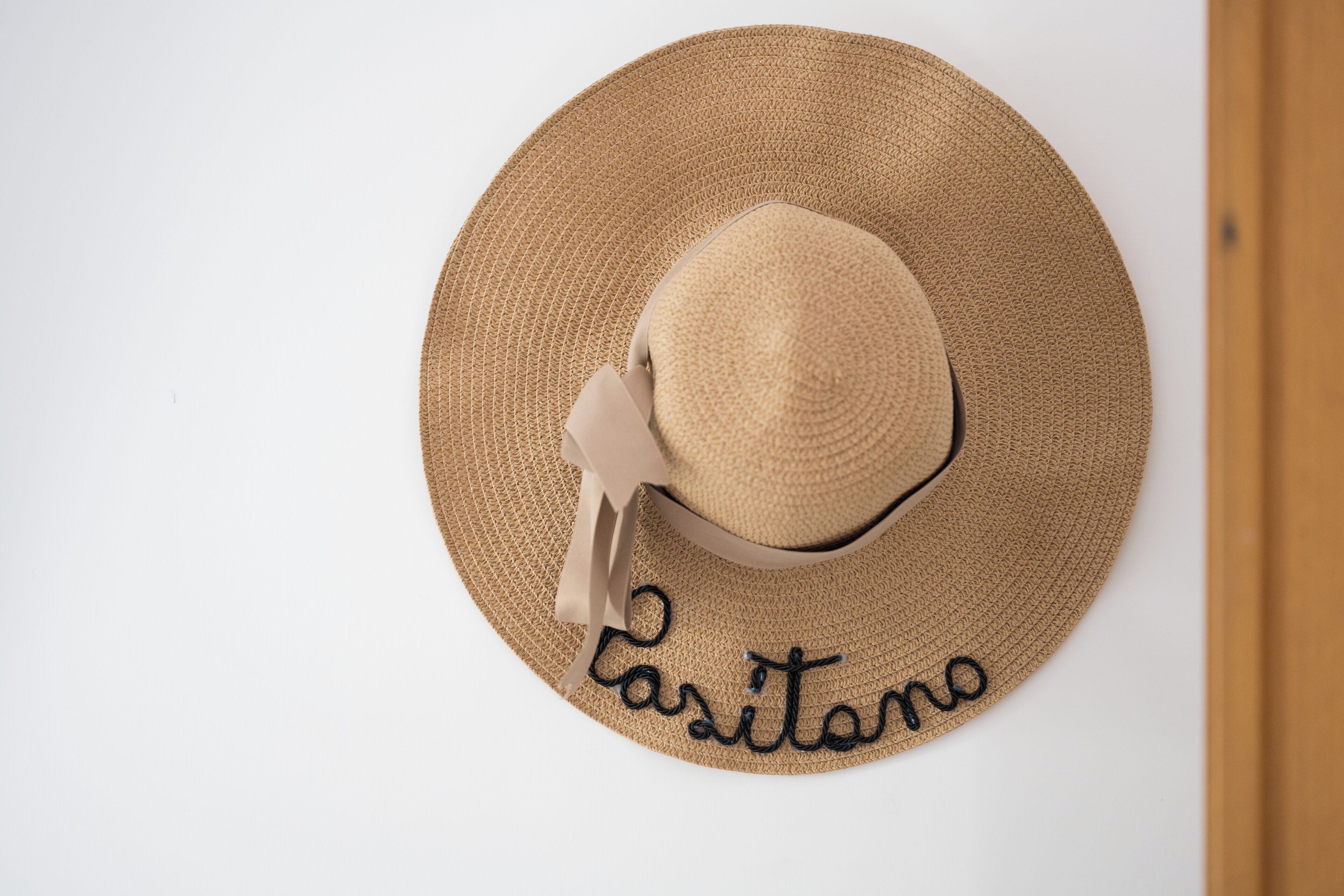 A straw hat with a ribbon and the word "Casitano" embroidered on it.