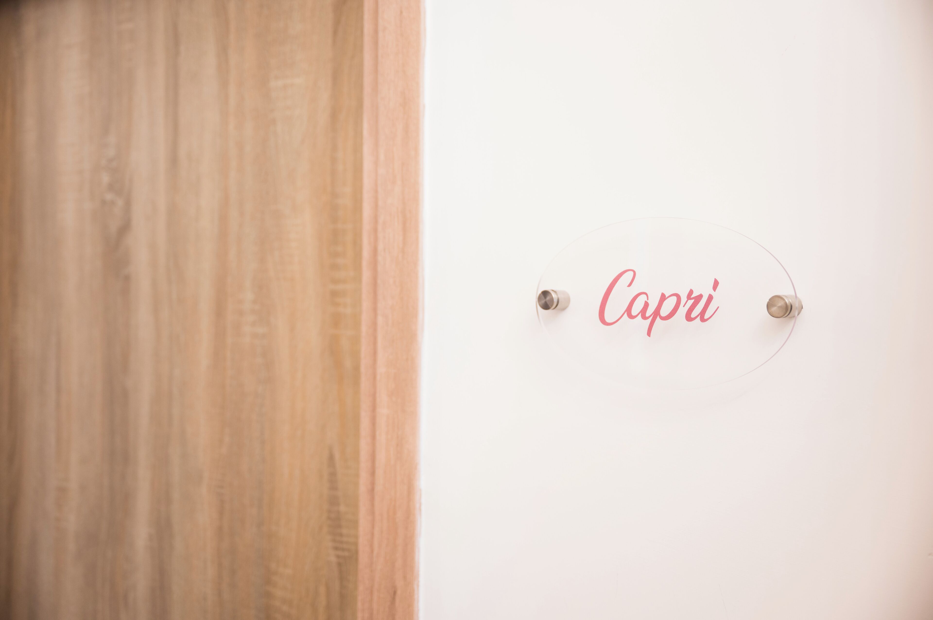 En trædør og en væg med et skilt, der står 'Capri'.