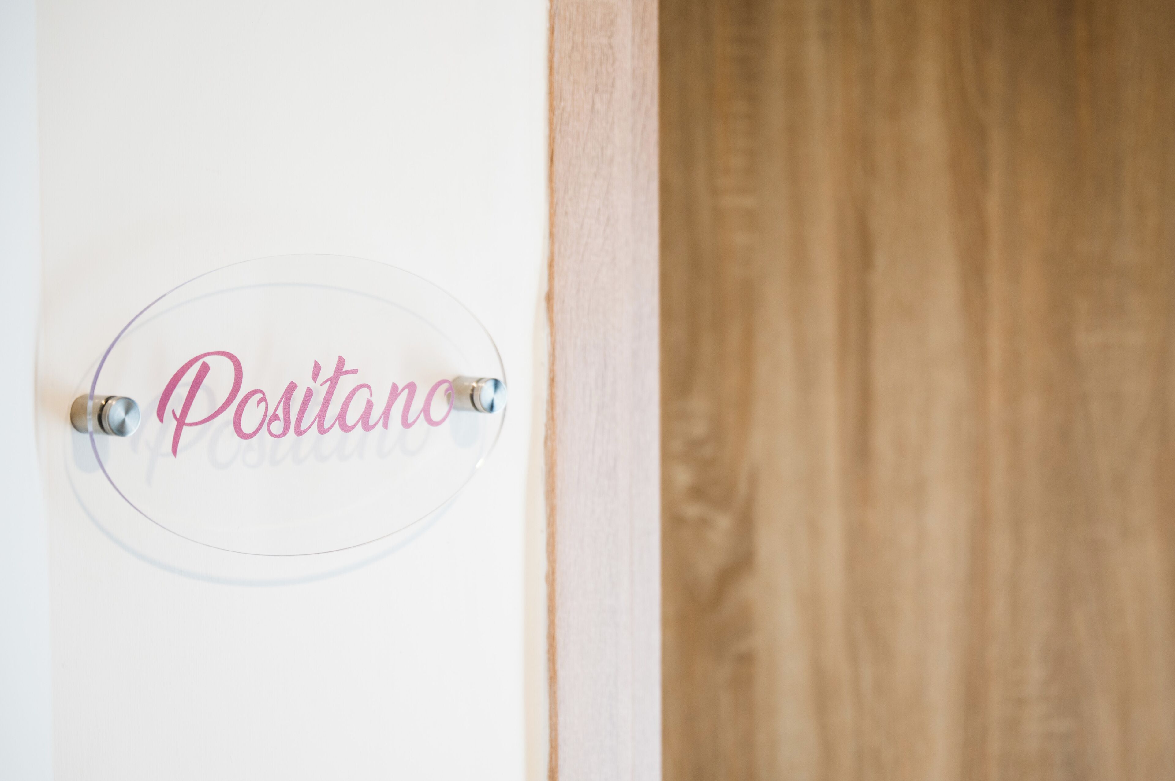 Una puerta con un letrero que dice 'Positano' y un marco de madera.