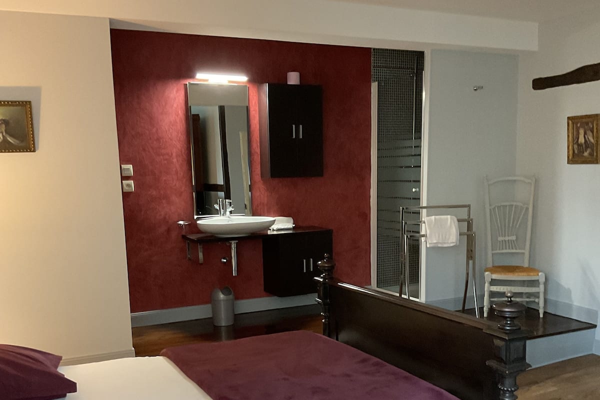 Une chambre à coucher comprenant un lit, une coiffeuse avec un miroir, une chaise et une table.