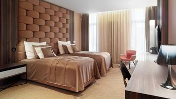 A modern hotel room with two beds, a desk, a chair, and a television.