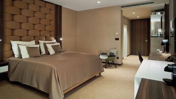 Ein modernes Hotelzimmer mit einem großen Bett, einem Schreibtisch und einem Sessel.