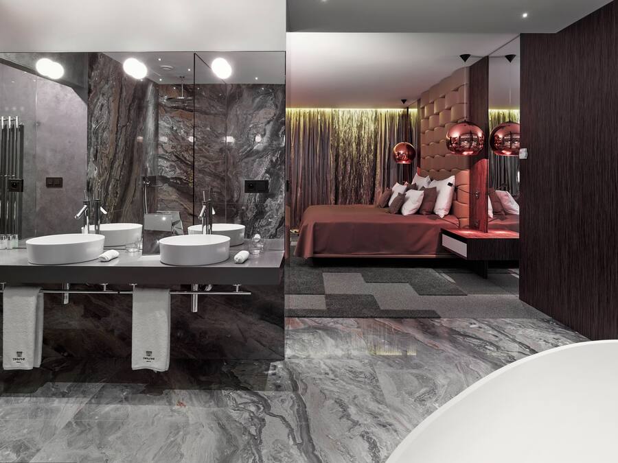 A modern bathroom with a large mirror, two sinks, and a toilet.