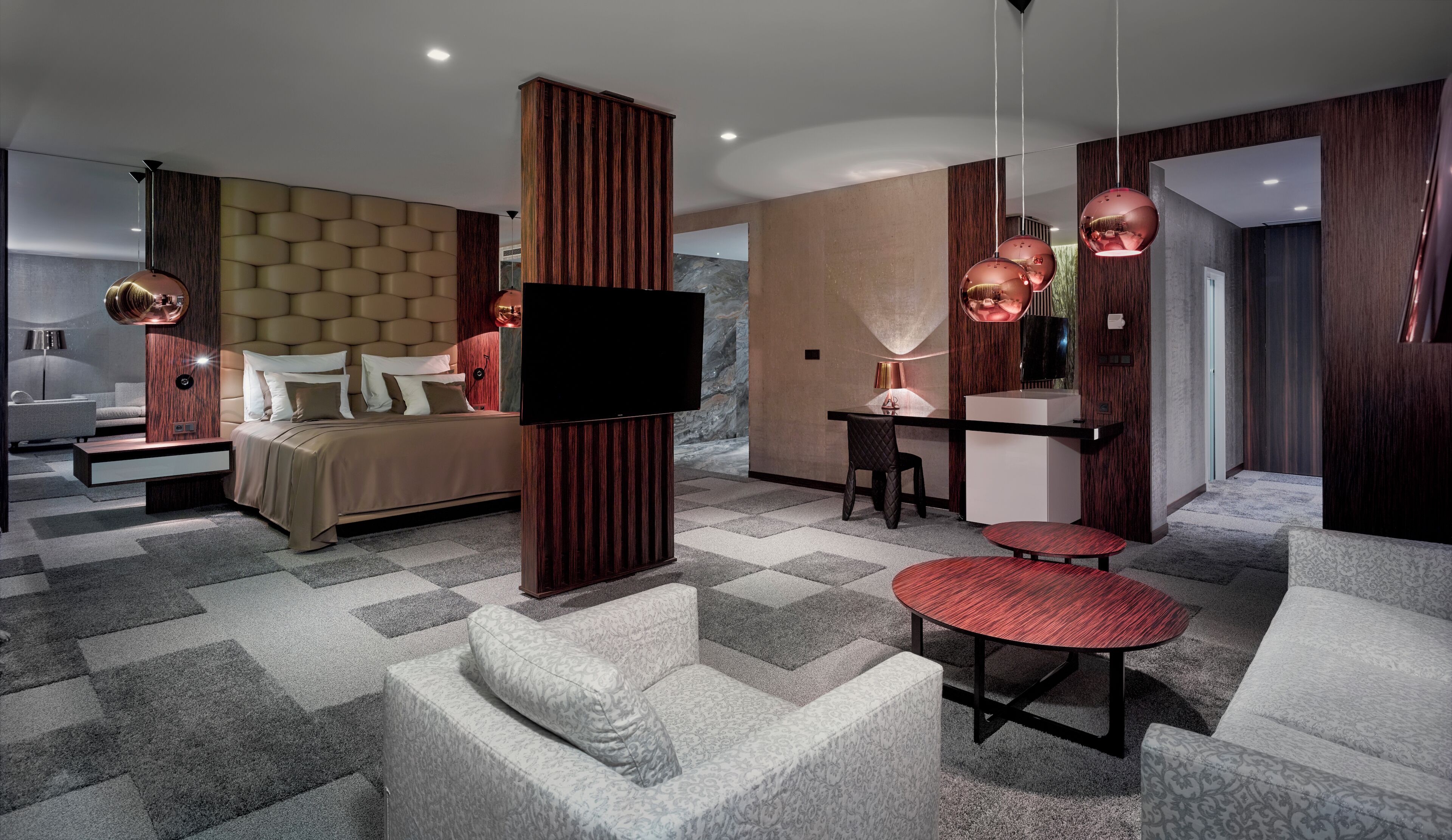 Une chambre d’hôtel moderne équipée d’un grand lit, d’un bureau, d’une télévision et d’un coin salon.