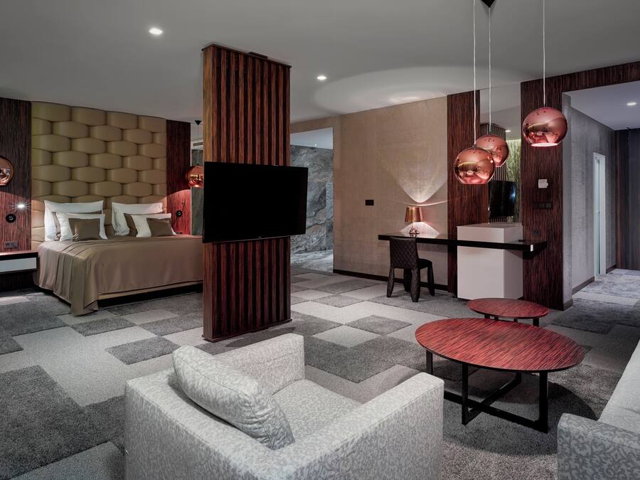 Une chambre d’hôtel moderne équipée d’un grand lit, d’un bureau, d’une télévision et d’un coin salon.