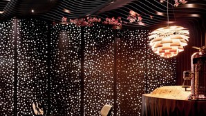 A room with a modern chandelier, a wooden table, and chairs. - Theatre Hotel (Olomouc)