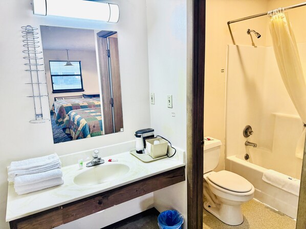 Un baño de hotel con lavamanos, inodoro y ducha.