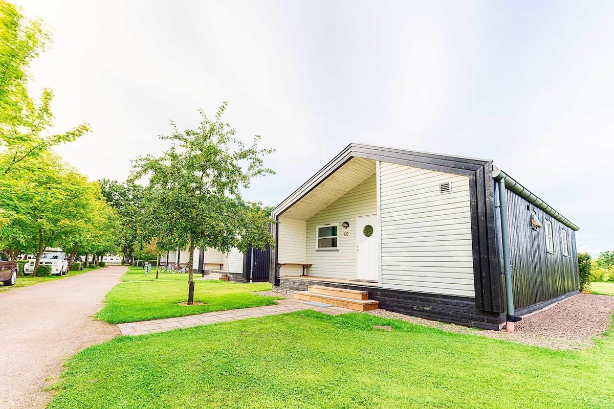A single-story mobile home with a front porch and a small window.