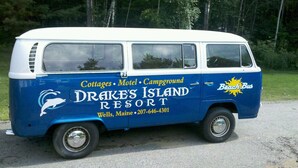 A blue and white van with "Drakes Island Resort" branding, indicating it is a mobile accommodation unit for travelers. - Drakes Island Resort (Wells)