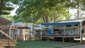 A mobile home with a covered porch and a small deck area. - Drakes Island Resort (Wells)