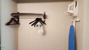 Un portascopevoli a parete con diversi appendiabiti e una borsa bianca con la scritta "UNDE".