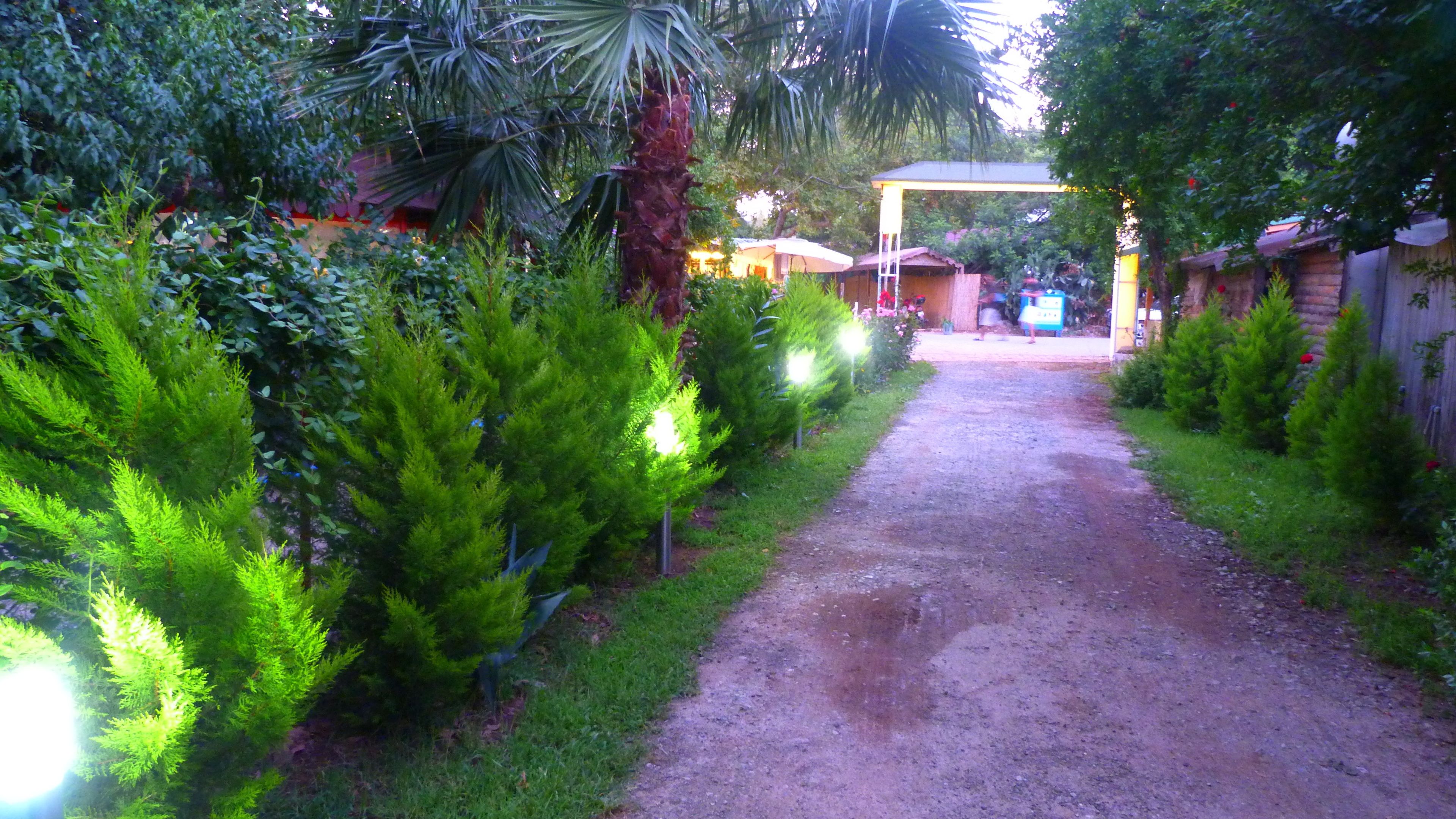 A pathway leading to a building with a covered entrance and a signboard.