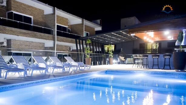Uma piscina com espreguiçadeiras e um bar.