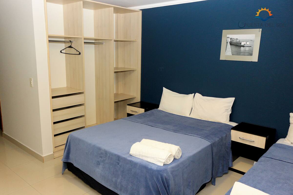 A bedroom with a bed, two bedside tables, a wardrobe, and a wall-mounted photo.