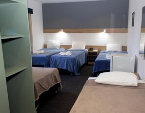 A hotel room with three beds, a desk, and a wardrobe. - Hotel Puesta del Sol (Encarnacion)