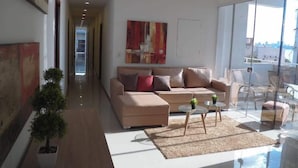 Uma sala de estar moderna com sofá, mesa de centro e planta em vaso.
