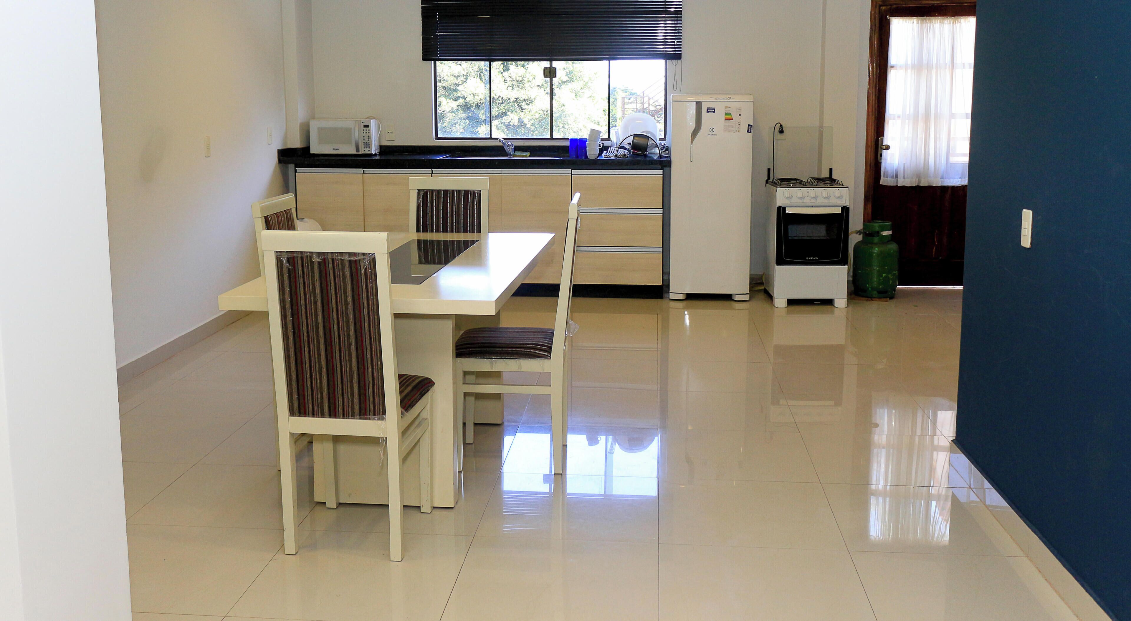 Una cocina compacta con comedor, ventana y refrigerador.