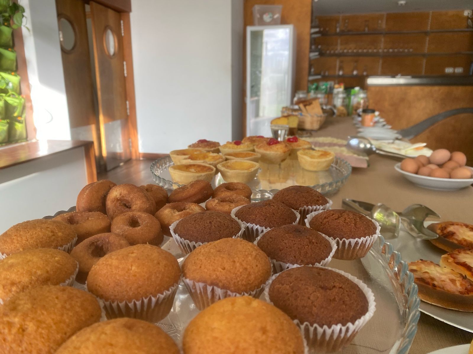 Une table de buffet proposant diverses pâtisseries, notamment des muffins et des tartes.