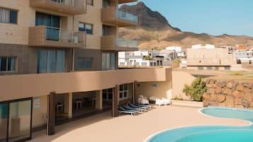 Una piscina al aire libre, tumbonas