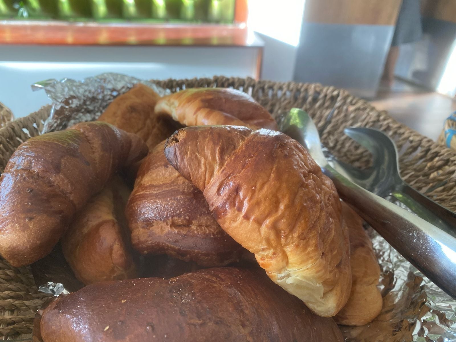 A basket of croissants on a table.