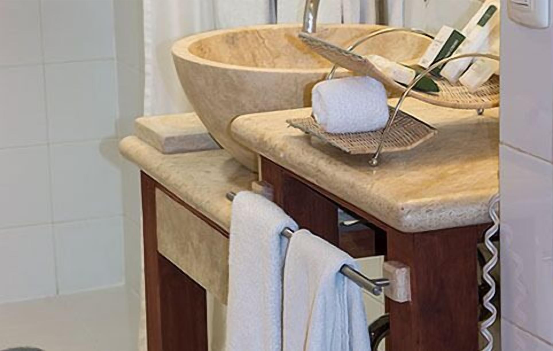 Un bagno con un lavabo in legno, un portasciuga e uno specchio.