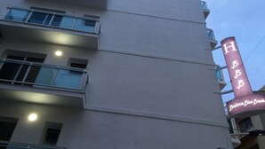 Ein mehrgeschossiges Gebäude mit einer auffälligen vertikalen Beschilderung, die die Buchstaben "HBB" und die Worte "Banidor Blue Beach" zeigt.