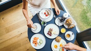 A dining table with various breakfast items including eggs, toast, and fruit. - Garden Hotel Reinhart (Prien am Chiemsee)