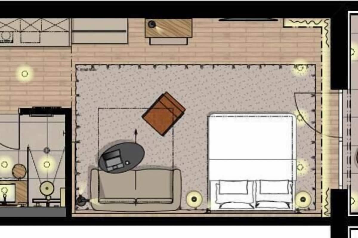 Distribución de una habitación de hotel con cama, zona de estar, escritorio y una pequeña kitchenette.