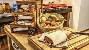 A bakery display with various baked goods and a sign indicating a pastry selection. - Holiday Inn Plovdiv by IHG (Plovdiv)