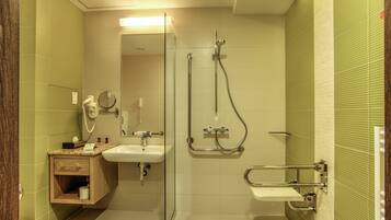 Un baño con cabina de ducha de vidrio, un lavamanos y un mueble de tocador con espejo.