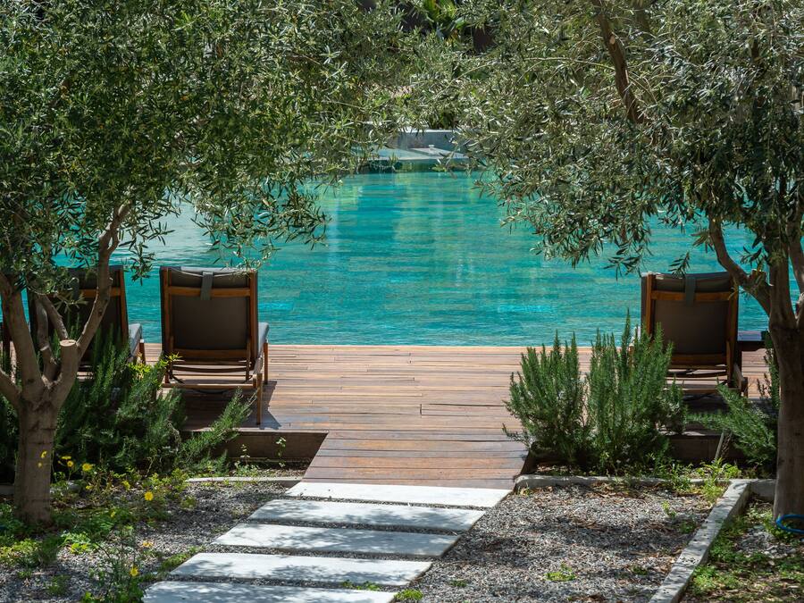 Una piscina al aire libre, sillones reclinables de piscina