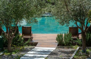 Una piscina al aire libre, sillones reclinables de piscina