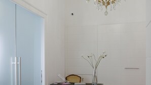 Een kamer met een houten tafel, een vaas met bloemen en een kroonluchter.