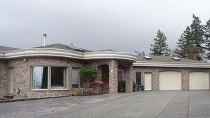 A two-story house with a brick facade, large windows, and a garage. - Gibralter Rock Ocean View B&B (Nanaimo)