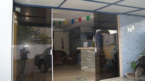 Una habitación con suelo de baldosas, una silla, una mesita y una pared con un mural.