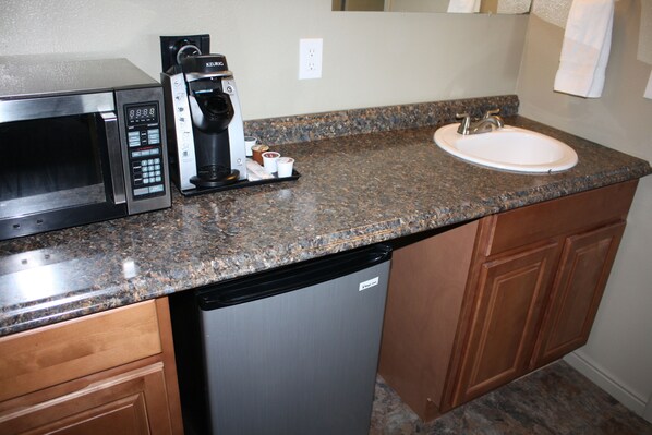 A kitchen with a microwave, coffee maker, and sink. - Gateway Inn (Lyman)