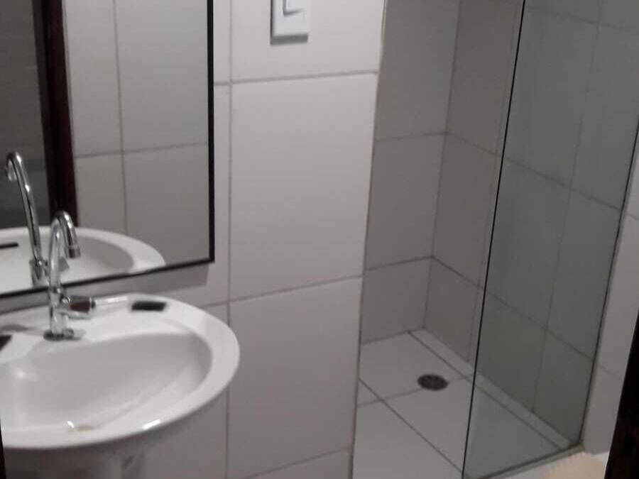 Une salle de bain équipée d’un lavabo, d’un miroir et d’un espace douche.