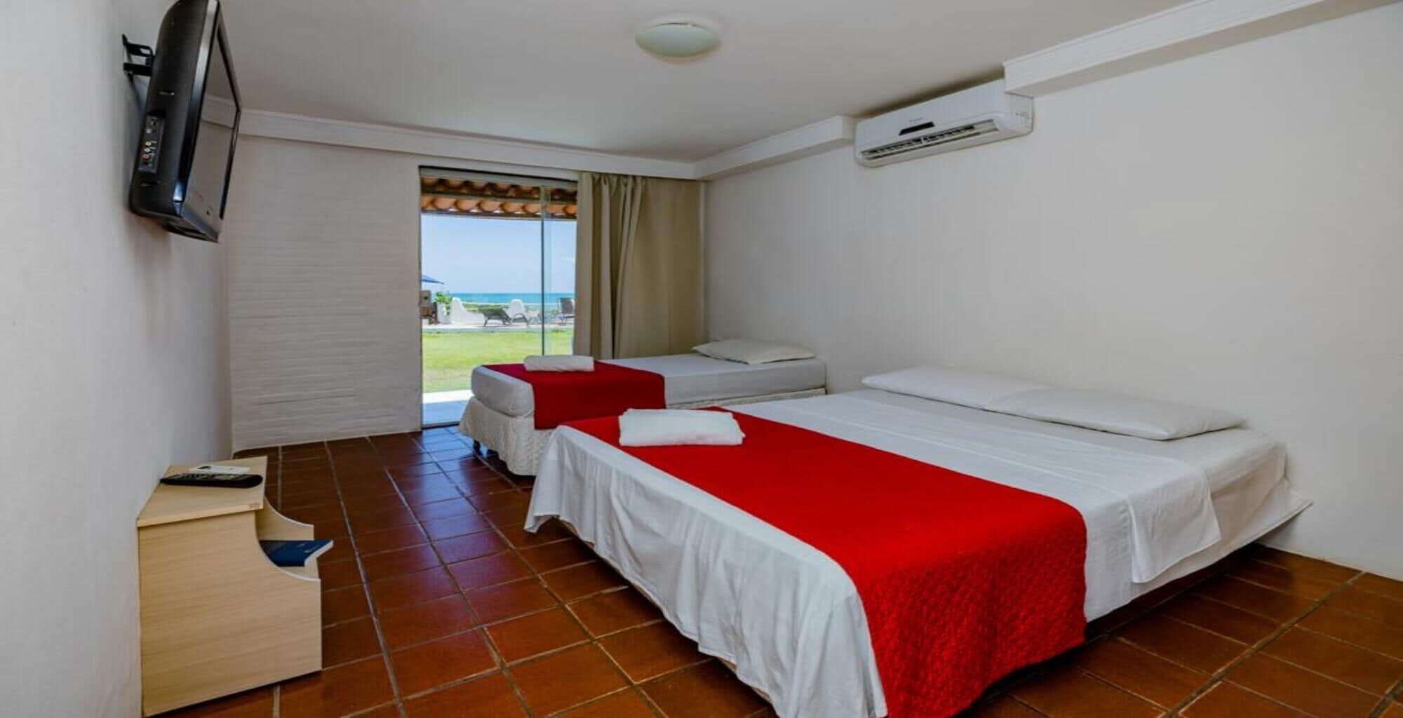Une chambre d’hôtel avec deux lits, une télévision, la climatisation et une vue sur l’extérieur.