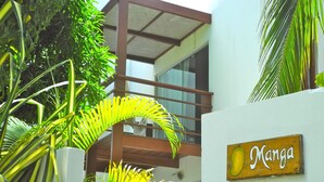 A building with a sign that reads "Manga" and a balcony with glass railings. - La Réserve Design Villas (Tibau do Sul)