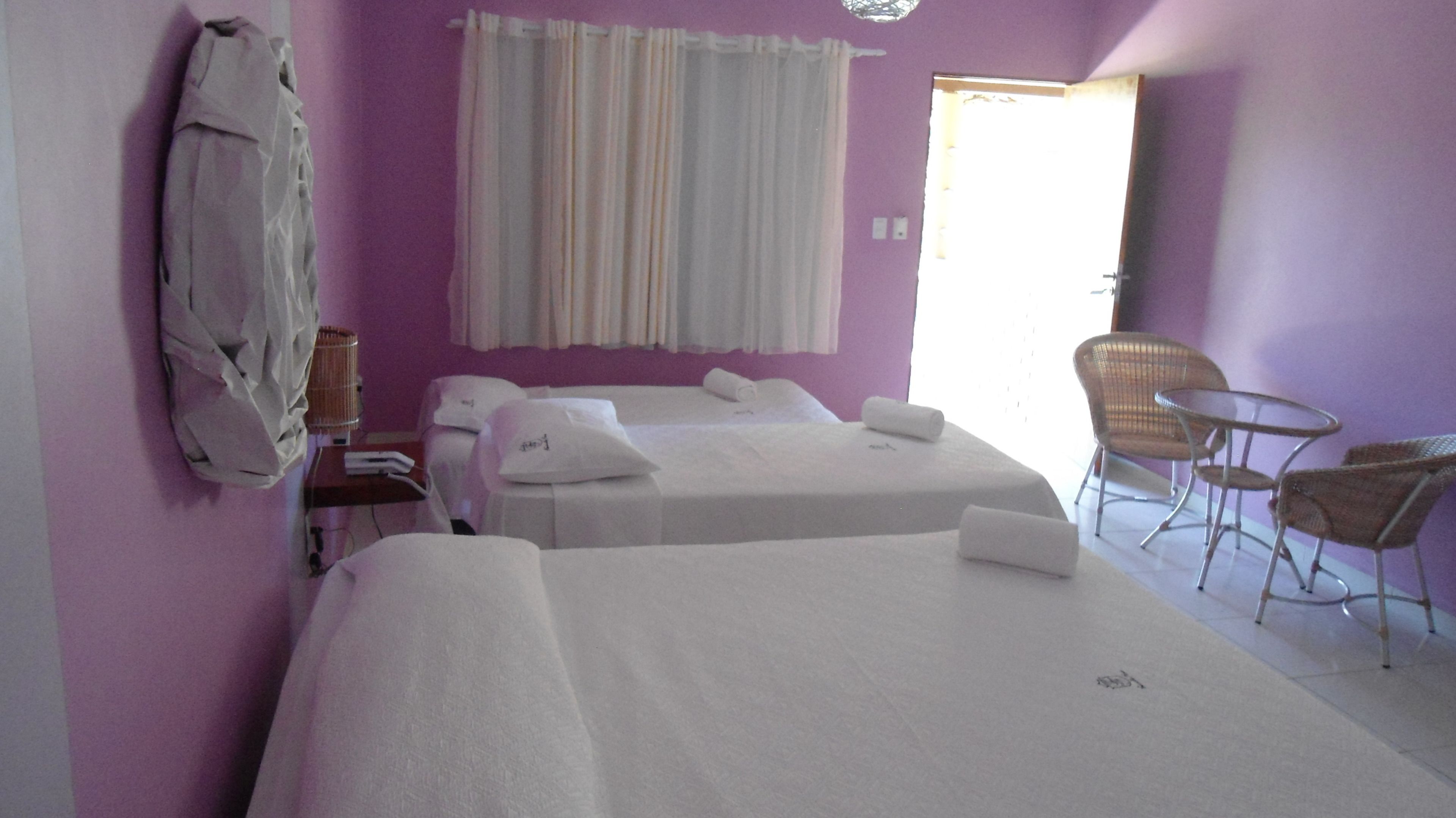 Camera d'albergo con due letti, una sedia e un tavolino.