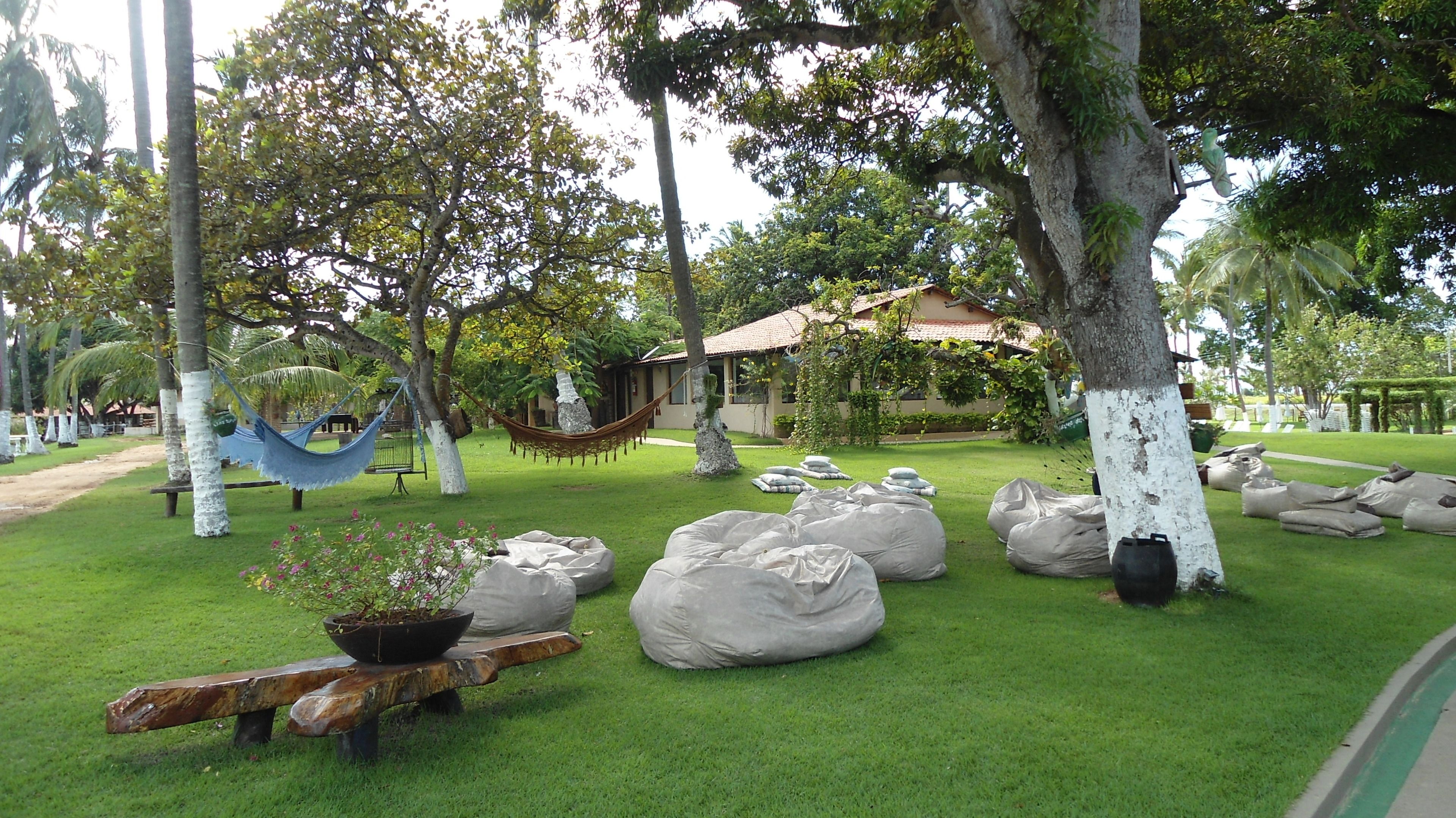 A well-maintained garden with a hammock, a bench, and large bags of soil.