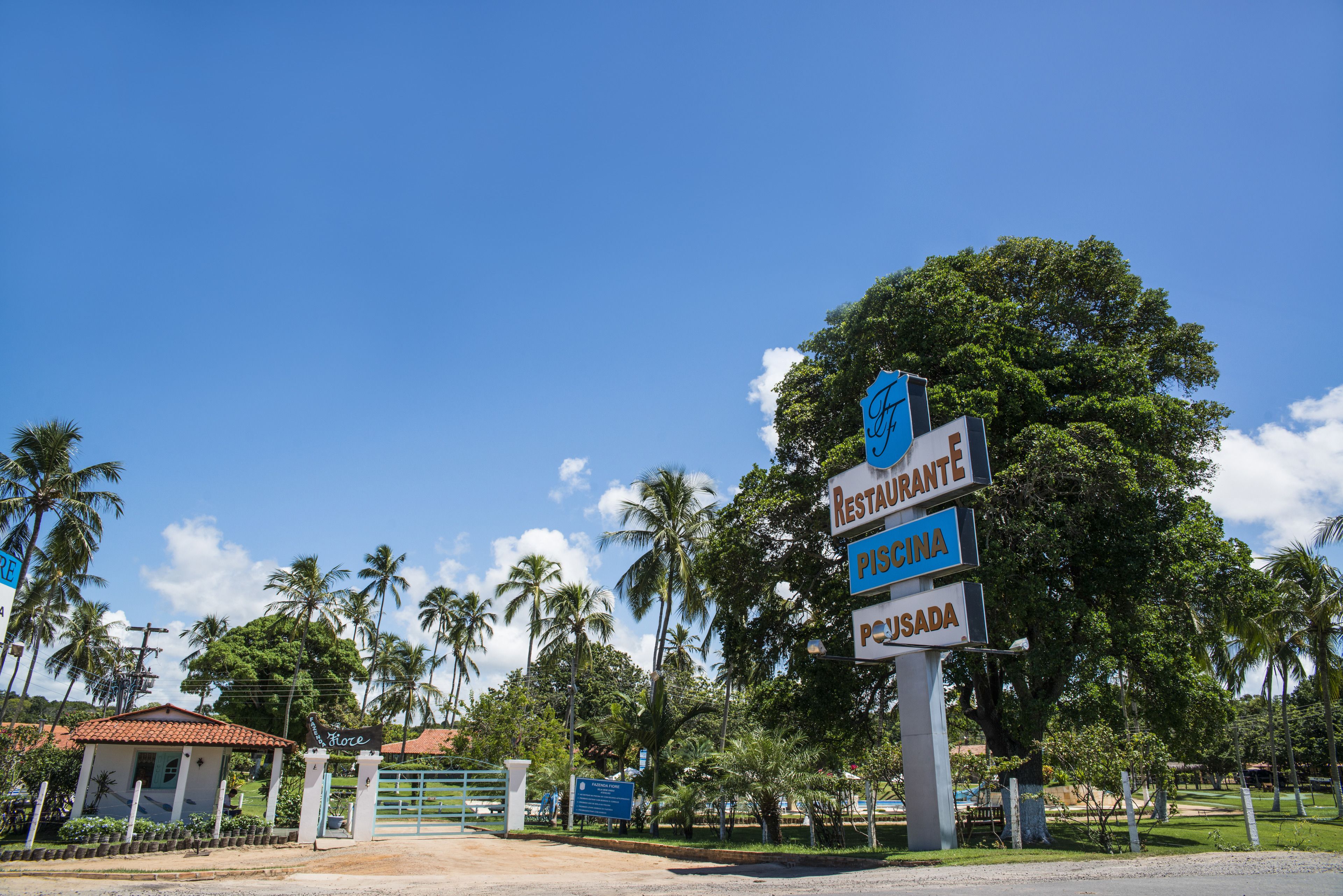 Placa de sinalização com várias direções, incluindo 'Restaurante', 'Piscina' e 'Piscada'.