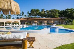 A pool area with lounge chairs, a hot tub, and a thatched-roof structure. - Fiore Resort e Residence (Paripueira)