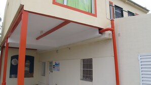Un bâtiment doté d’une entrée couverte, d’une porte et d’une fenêtre avec des barreaux en métal.