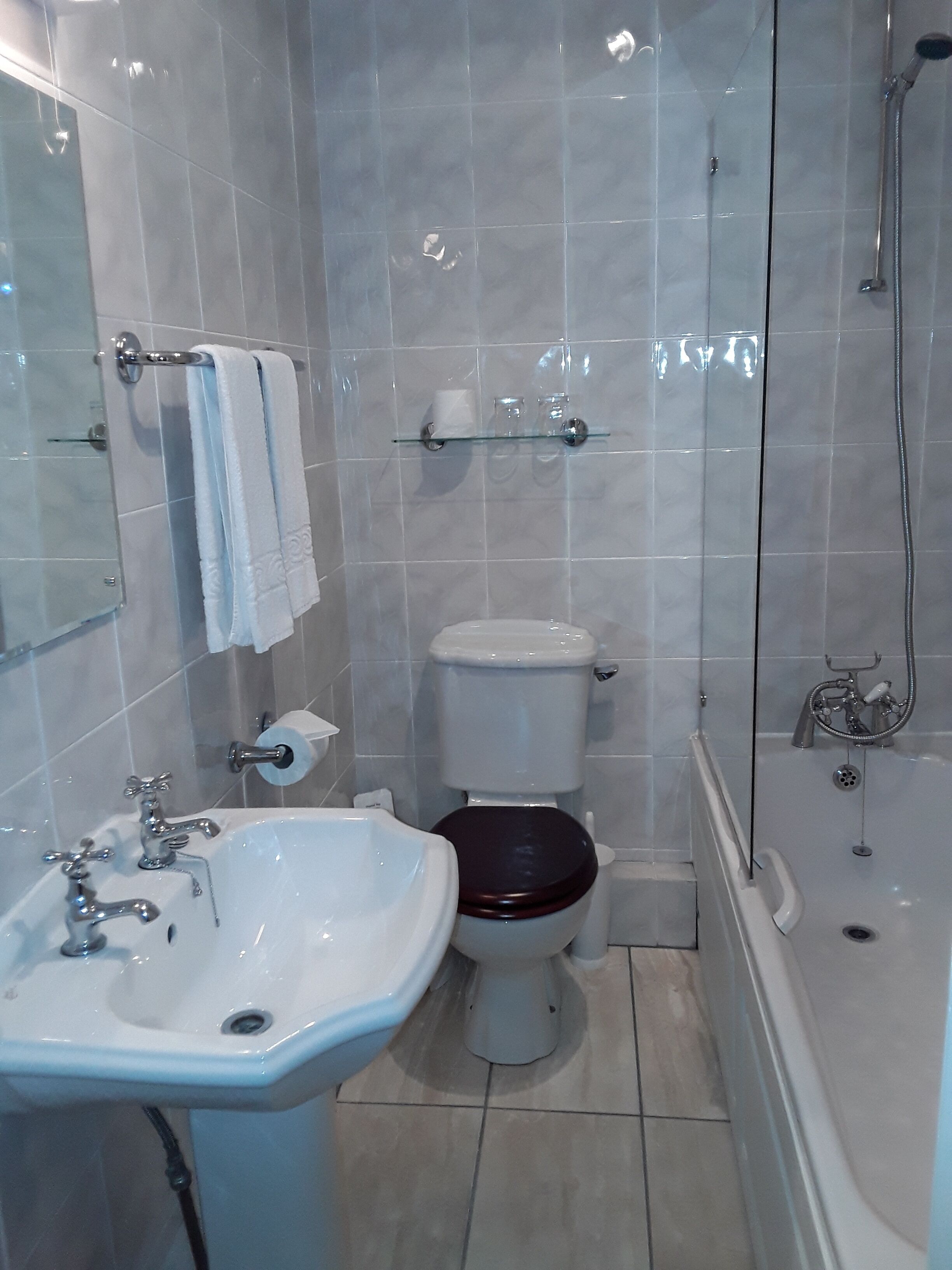 A bathroom with a bathtub, a sink, a toilet, and a glass shower enclosure.