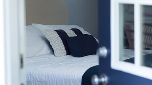 Un dormitorio con una cama, una puerta y un cuadro en la pared.