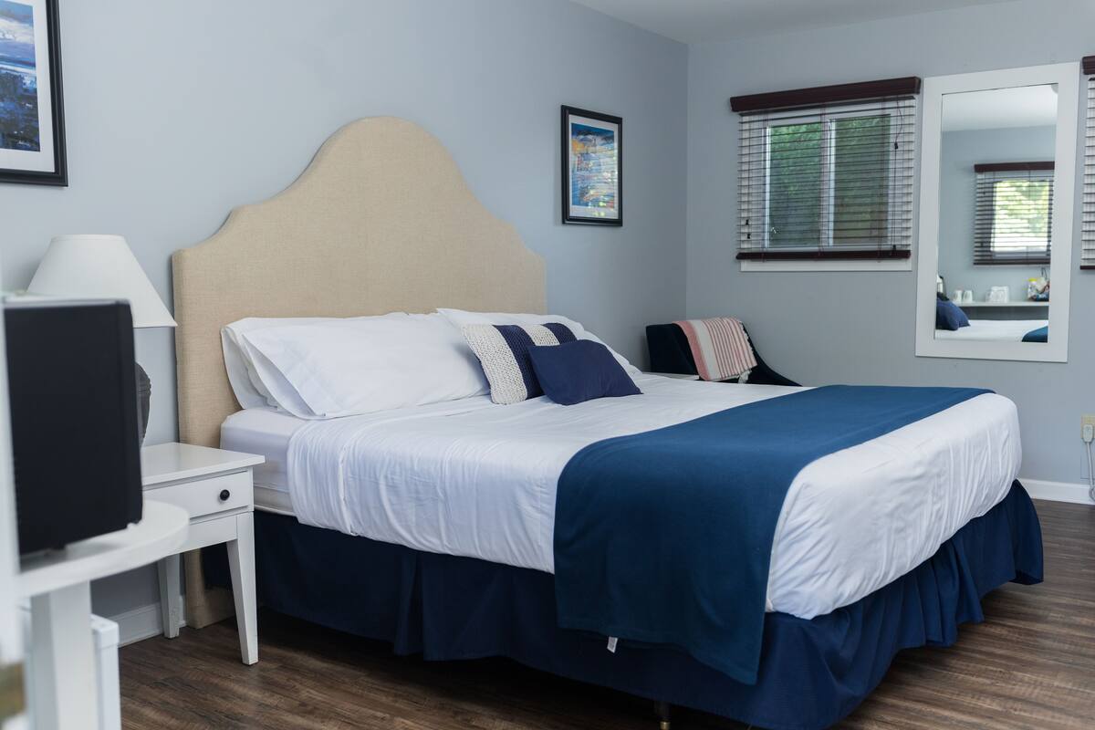 A neatly arranged bedroom with a bed, bedside table, and a television.